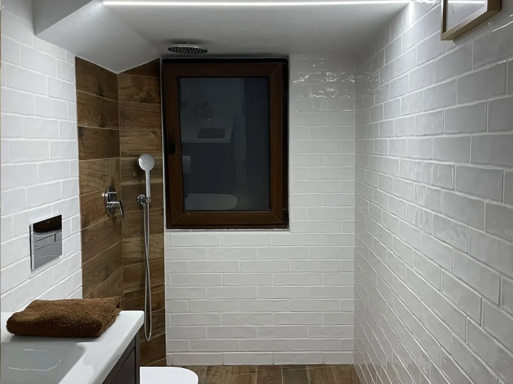 Baño azulejo blanco y madera · Tarraula